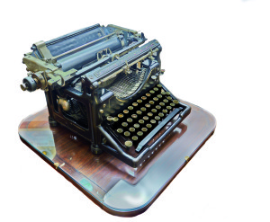 An old manual typewriter on a wooden table - isolated on white